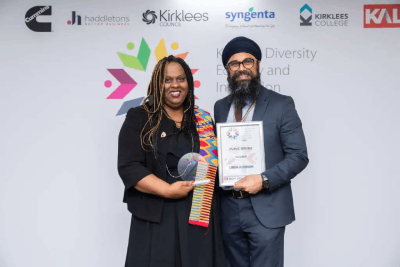 Two people holding an award and certificate smiling